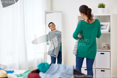 Image of woman packing travel bag at home or hotel room