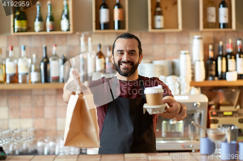 Image of man or waiter with coffee and paper bag at bar