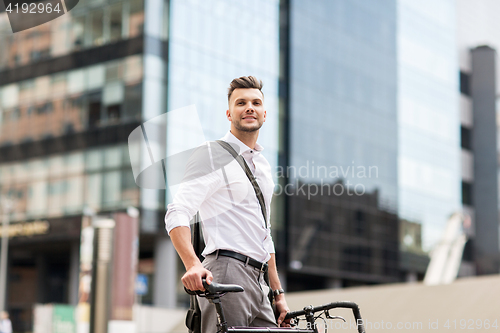 Image of young man with bicycle on city street