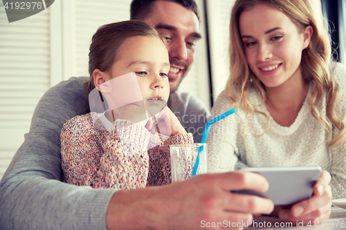 Image of happy family with smartphone at restaurant