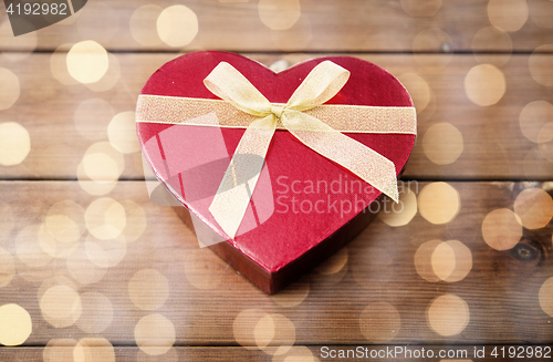 Image of close up of heart shaped gift box on wood