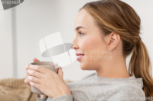 Image of happy woman with cup or mug drinking at home