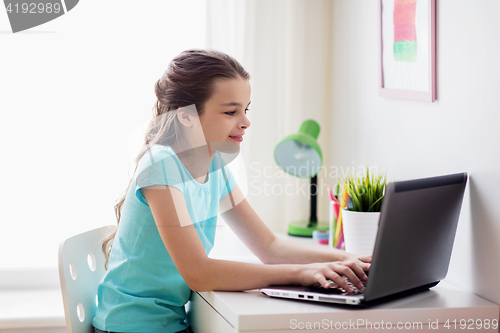 Image of girl typing on laptop at home