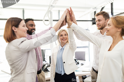 Image of happy business team making high five at office