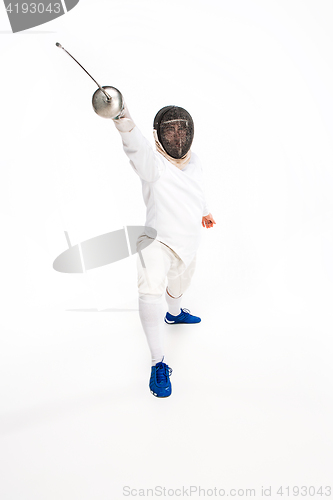 Image of Man wearing fencing suit practicing with sword against gray