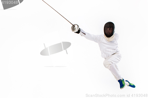 Image of Man wearing fencing suit practicing with sword against gray