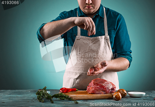 Image of Butcher cutting pork meat on kitchen