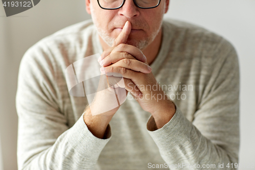 Image of close up of senior man in glasses thinking