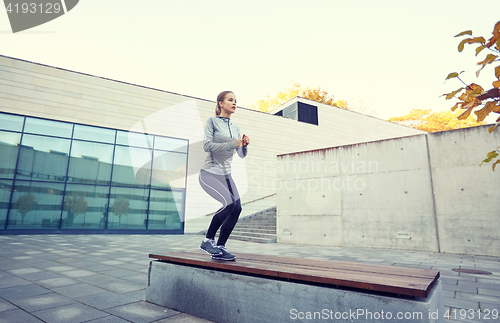 Image of woman exercising on bench outdoors