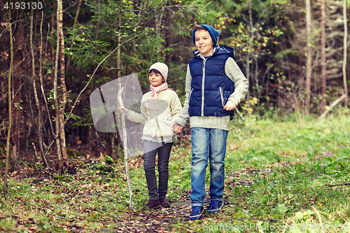 Image of two happy kids walking along forest path