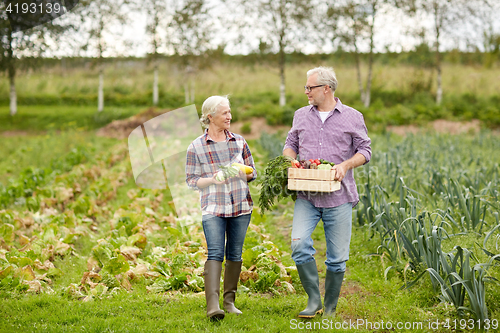 Image of senior couple with box of vegetables on farm