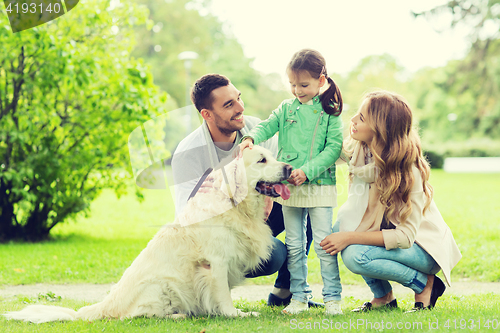 Image of happy family with labrador retriever dog in park