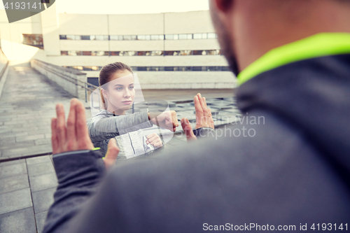 Image of woman with trainer working out self defense strike