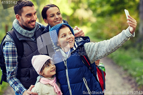 Image of family taking selfie with smartphone in woods