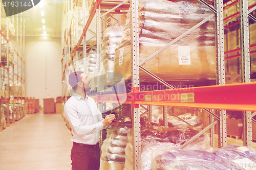 Image of businessman with clipboard at warehouse