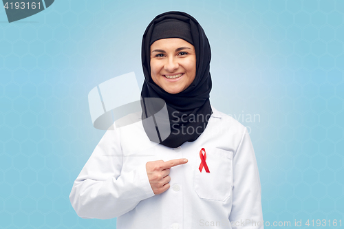 Image of muslim doctor in hijab with red awareness ribbon