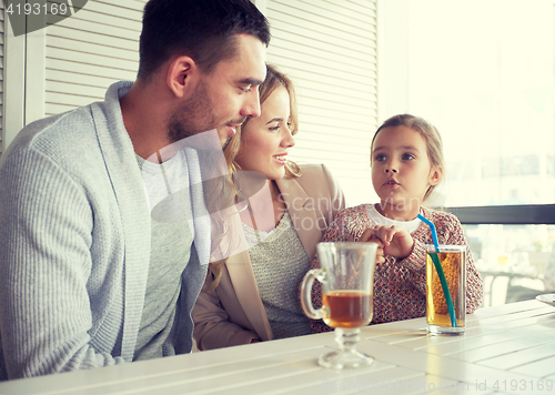 Image of happy family having dinner at restaurant or cafe