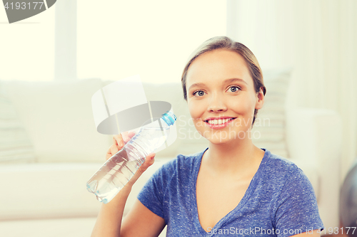 Image of happy woman with water bottle at home