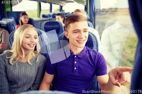 Image of happy teenage couple or passengers in travel bus