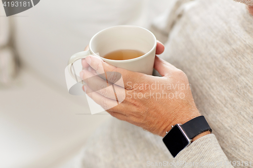 Image of close up of senior man with tea and wristwatch