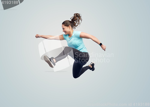 Image of happy smiling sporty young woman jumping in air