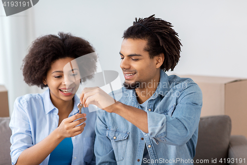 Image of happy couple with key and boxes moving to new home