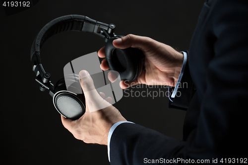 Image of close up of businessman hands holding headphones