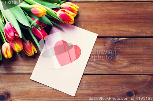 Image of close up of flowers and greeting card with heart