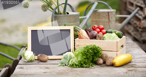 Image of close up of vegetables with chalkboard on farm