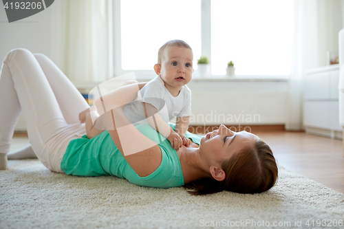 Image of happy mother playing with baby at home