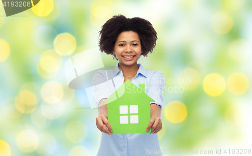 Image of happy african american woman with green house icon