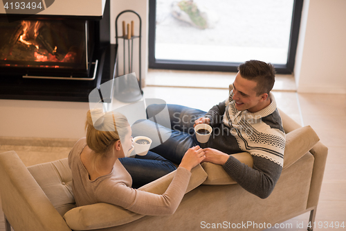 Image of Young couple  in front of fireplace