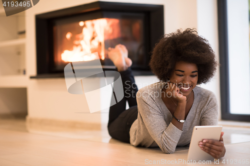 Image of black women used tablet computer on the floor