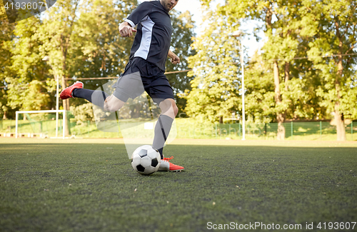 Image of soccer player playing with ball on football field