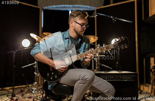 Image of man playing guitar at studio rehearsal