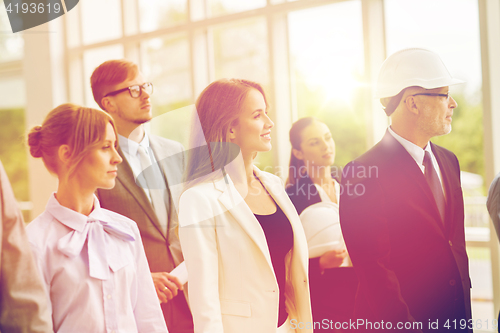 Image of business team in helmets walking along office