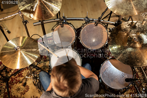 Image of male musician playing drums and cymbals at concert