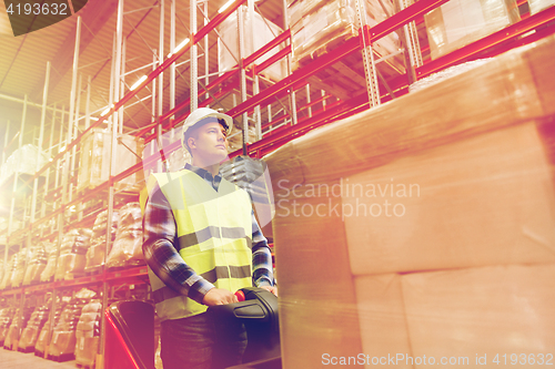 Image of man on forklift loading cargo at warehouse