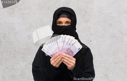 Image of muslim woman in hijab with money over white