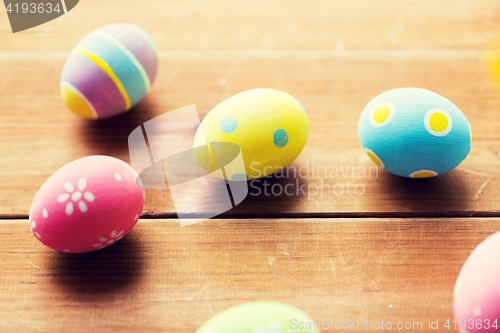 Image of close up of colored easter eggs on wooden surface