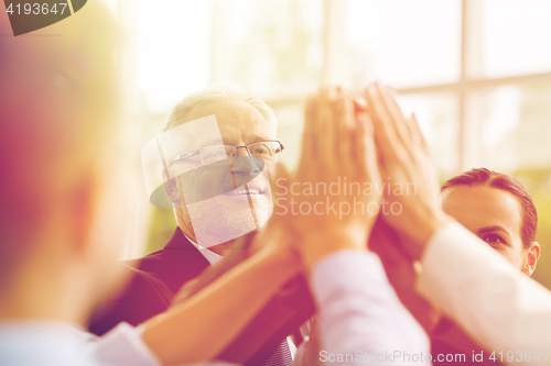 Image of business people making high five in office