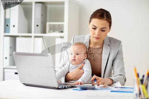 Image of businesswoman with baby working at office