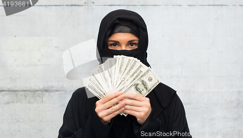 Image of muslim woman in hijab with money over white