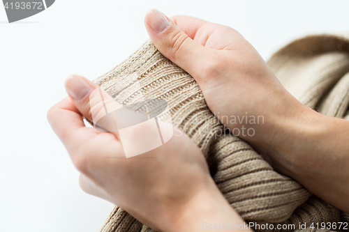 Image of close up of hands with knitted clothing item