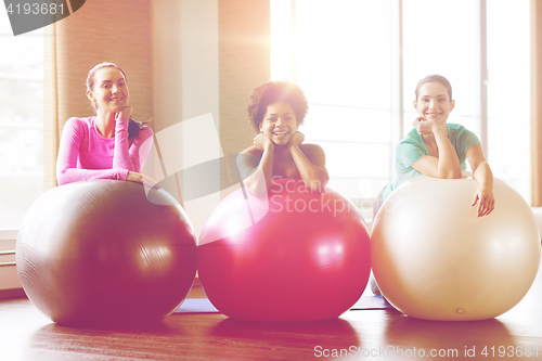 Image of group of smiling women with exercise balls in gym