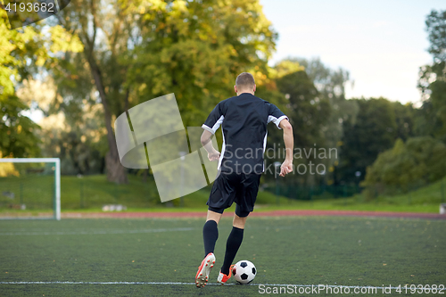 Image of soccer player playing with ball on football field