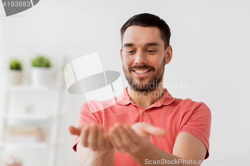 Image of happy man holding something imaginary at home