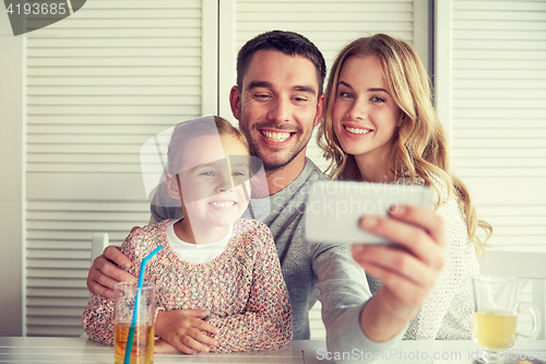 Image of happy family taking selfie at restaurant
