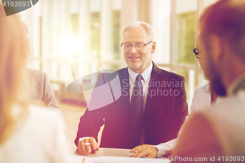 Image of smiling business people meeting in office