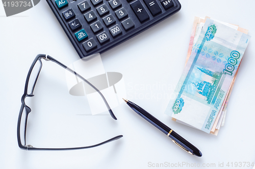 Image of Business concept: glasses, pen, calculator and money